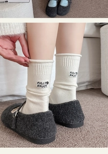 Nahaufnahme der weißen Ripp-Kaschmirsocken mit Stickerei und weichen Plüschschuhen
