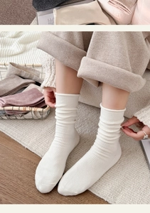Detailed knit texture of white ribbed crew socks with various neutral color options