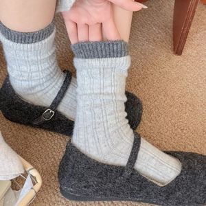 Thick wool blend mid-calf socks with ribbed cuffs paired with grey Mary Jane shoes