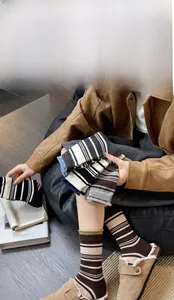 Collection of thick winter wool striped socks in earthy tones held by a model