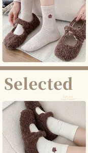 Detailed close-up of cozy bear embroidery on thick wool socks and plush Mary Jane slippers