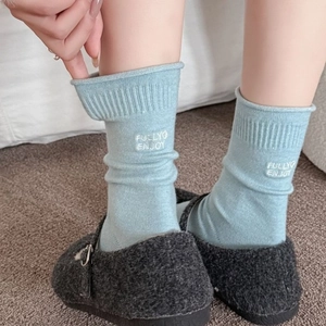 Dicke hellblaue Kaschmir-Socken mit weißer Stickerei und Mary-Jane-Schuhen kombiniert