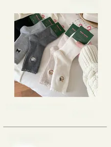 Close-up of five pairs of wool-like cotton socks with cat embroidery and lace trim