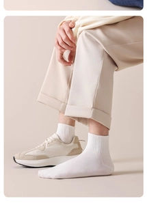 Dettaglio di calzini in cotone bianco a coste abbinati a pantaloni e sneakers