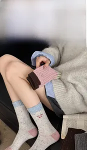 Detail view of thick wool socks with 'ALL THE BEST' embroidery and contrast color design