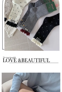 Detailed view of polka dot cotton socks with ruffled cuffs and M.E.K. brand woven labels