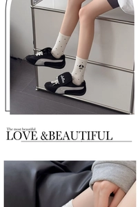 Detail of white cotton mid-tube socks with black polka dots and a cute puppy graphic