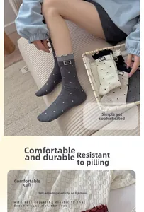 Detail view of cotton blend crew socks with white polka dots and grey frill cuff design