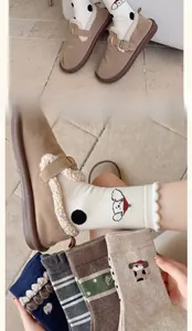 Close-up of winter wool socks featuring cute dog embroidery and striped patterns