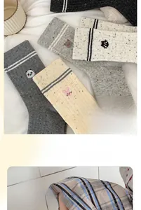 Close-up of cute animal embroidery and elastic cuffs on striped cotton crew socks