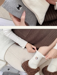 Close-up of embroidery cat pattern and ruffled edge on winter wool socks for women