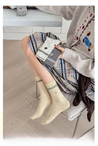Close-up of nep yarn socks featuring animal embroidery and ribbed texture cuffs