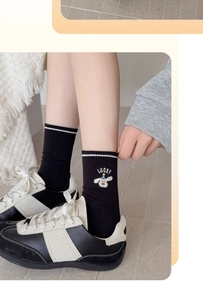 Close-up of black cotton mid-calf socks with white puppy embroidery and Lucky lettering