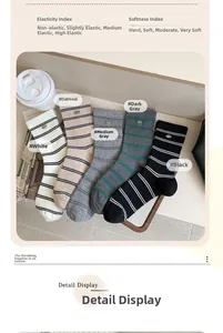 Detail view of five colors ribbed socks with metal logo tags on a wooden tray