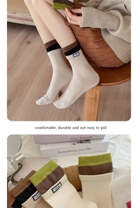 Detail von cremefarbenen Strickstrümpfen mit Kontraststreifen und Stoffetikett