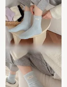 Detailed view of light blue plush mink velvet socks with handmade woven label detail