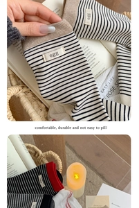 Detail of striped cotton socks featuring a stitched egg label and soft knit texture