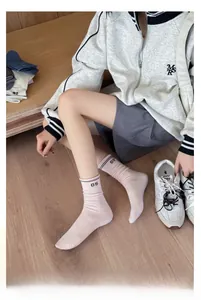 Detail of light pink ribbed crew socks with number 05 print and athletic college style