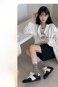 Close-up of gray striped socks with silver button accent and sporty casual shoes