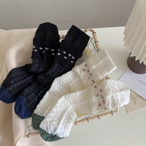 Retro floral socks with relief knit tulip patterns and ruffled cuffs in black and white