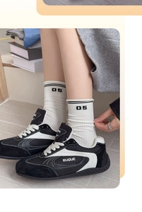 Detail of white cotton athletic socks featuring black 05 number and striped pattern cuffs