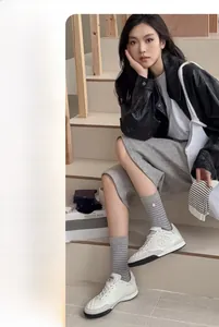 Détails de chaussettes en coton à rayures gris clair avec baskets blanches pour un look décontracté