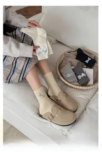 Detailed shot of knitted crew socks featuring cute blue striped bows and lace accents