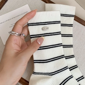 White ribbed crew socks with black stripes and silver Smile metal plaque detail