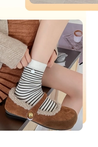 Détail de chaussettes en coton à fines rayures noires et blanches avec bords côtelés
