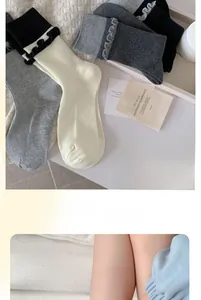 Dettaglio di calze in maglia a costine con eleganti bordi in pizzo a smerlo neutri