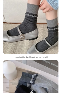Dettaglio di calzini grigi con volant, trama in maglia e cuciture a contrasto alla moda