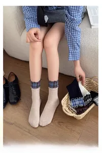 Close-up of beige crew socks with blue checkered frill trim and ribbed cotton texture