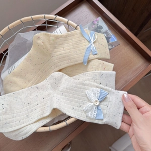 Cute Korean style dot yarn crew socks with bow and lace trim in a wicker basket