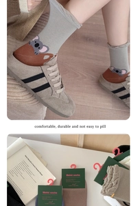 Detail of grey crew socks featuring 3D cartoon koala embroidery and ribbed cuffs