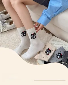 Detail of cute cotton crew socks with cartoon cat face and colorful polka dots patterns