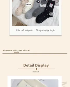 Close-up of cat embroidery and polka dot patterns on soft grey cotton crew socks