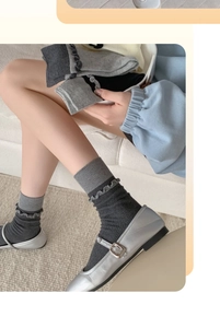 Dettaglio calzini grigi con balze abbinati a scarpe Mary Jane color argento