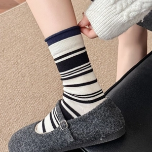 Thick warm wool crew socks with black and white stripes and navy rolled edges for women