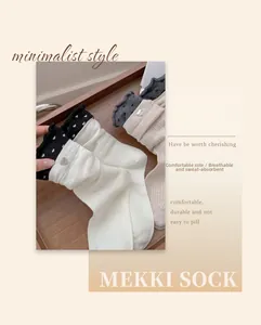 Detailed knit texture of ribbed mid-calf socks with heart buckle and frilly edges