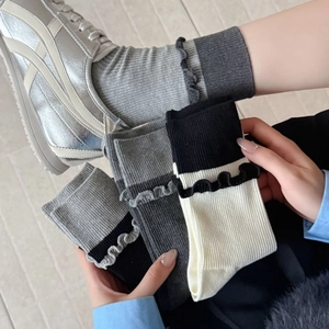 Calze a coste con bordo in pizzo in beige, nero e grigio abbinate a sneakers argento