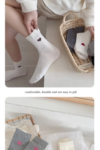 Détail de la broderie cœur sur chaussettes mi-mollet en coton côtelé blanc et gris