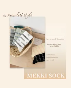 Atmungsaktive gestreifte Baumwollsocken mit Welpen-Etikett im gemütlichen Korb