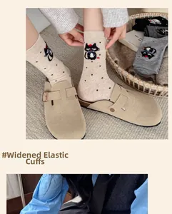 Detail of widened elastic cuff on beige cotton mid-calf socks with black cat pattern