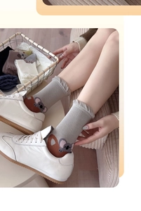 Close-up of cotton crew socks in light grey with cute koala pattern and ruffled trim