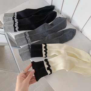 Tre paia di calze a costine con volant in nero, grigio e crema con bordo decorativo