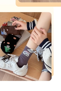 Detail of high-elastic cotton socks with cartoon dinosaur and cloud patterns for women