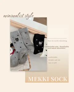 Détail de la broderie chat et texte MEOW sur chaussettes en coton à motif d'étoiles