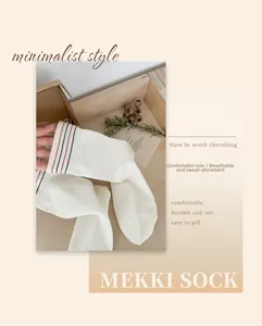 Close-up of white cotton crew socks with red and black stripes on a wooden tray