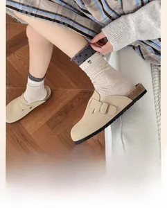 Detail of beige ribbed crew socks with lettuce edge cuffs and black heart embroidery