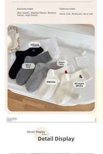 Détail des chaussettes en coton avec broderie cœur dans les tons noir, gris et blanc